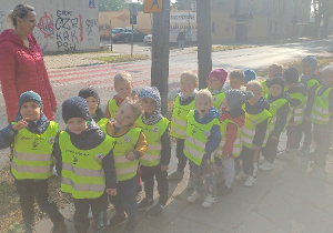 Dzieci stoją przy znakach drogowych